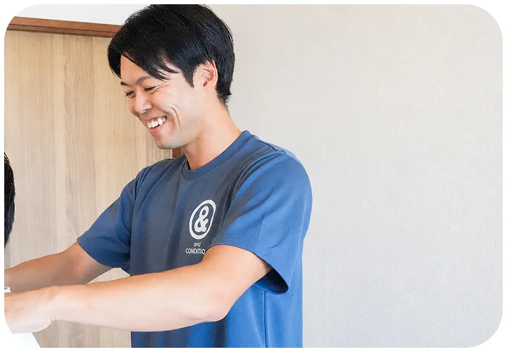 笑顔で施術するコンディショニングトレーナー